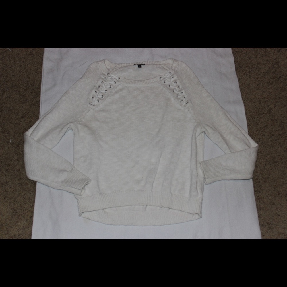 White sweater with cross stitching on front